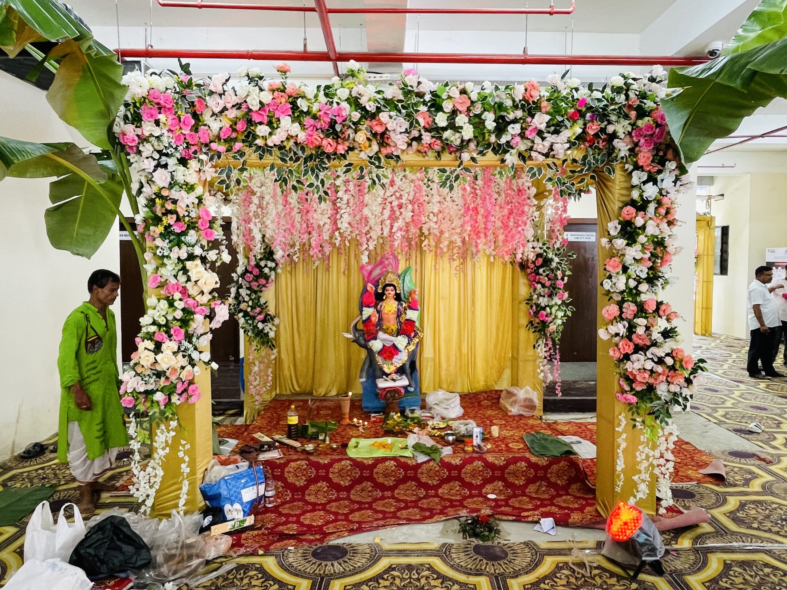Devotees beside a decorated Vishwakarma idol during a workplace Puja celebration at Oil India Limited, Duliajan, Assam