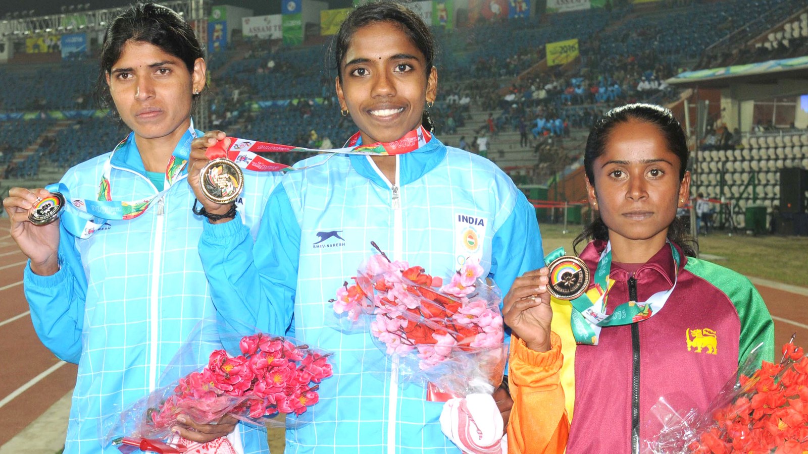 Indian runners L. Surya and Swaty Gadhave holding gold and silver medals on the podium for the women's 10000m at a past multi-sport athletics event, the same discipline Seema Kumari won bronze in at the 2026 Asian Games