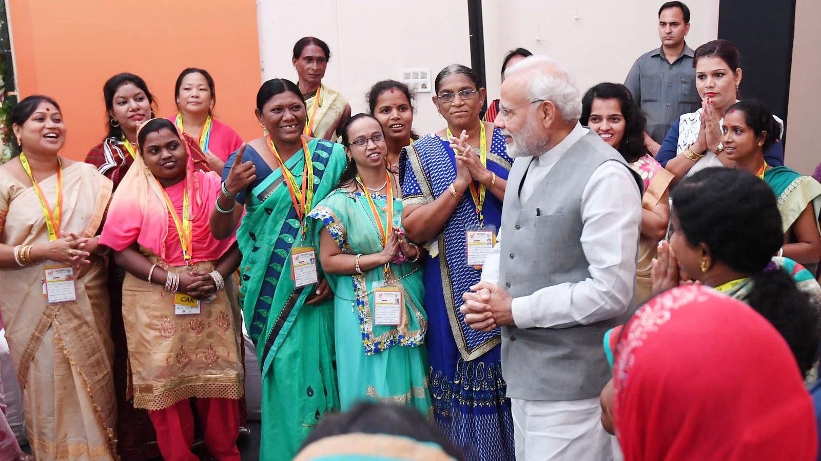 Prime Minister Narendra Modi greets a group of women beneficiaries of Pradhan Mantri Awas Yojana Urban at an event in Lucknow, Uttar Pradesh
