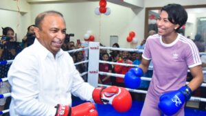 Boxer Lovlina Borgohain smiling in blue gloves as she spars playfully with Devajit Saikia inside a boxing ring in Guwahati