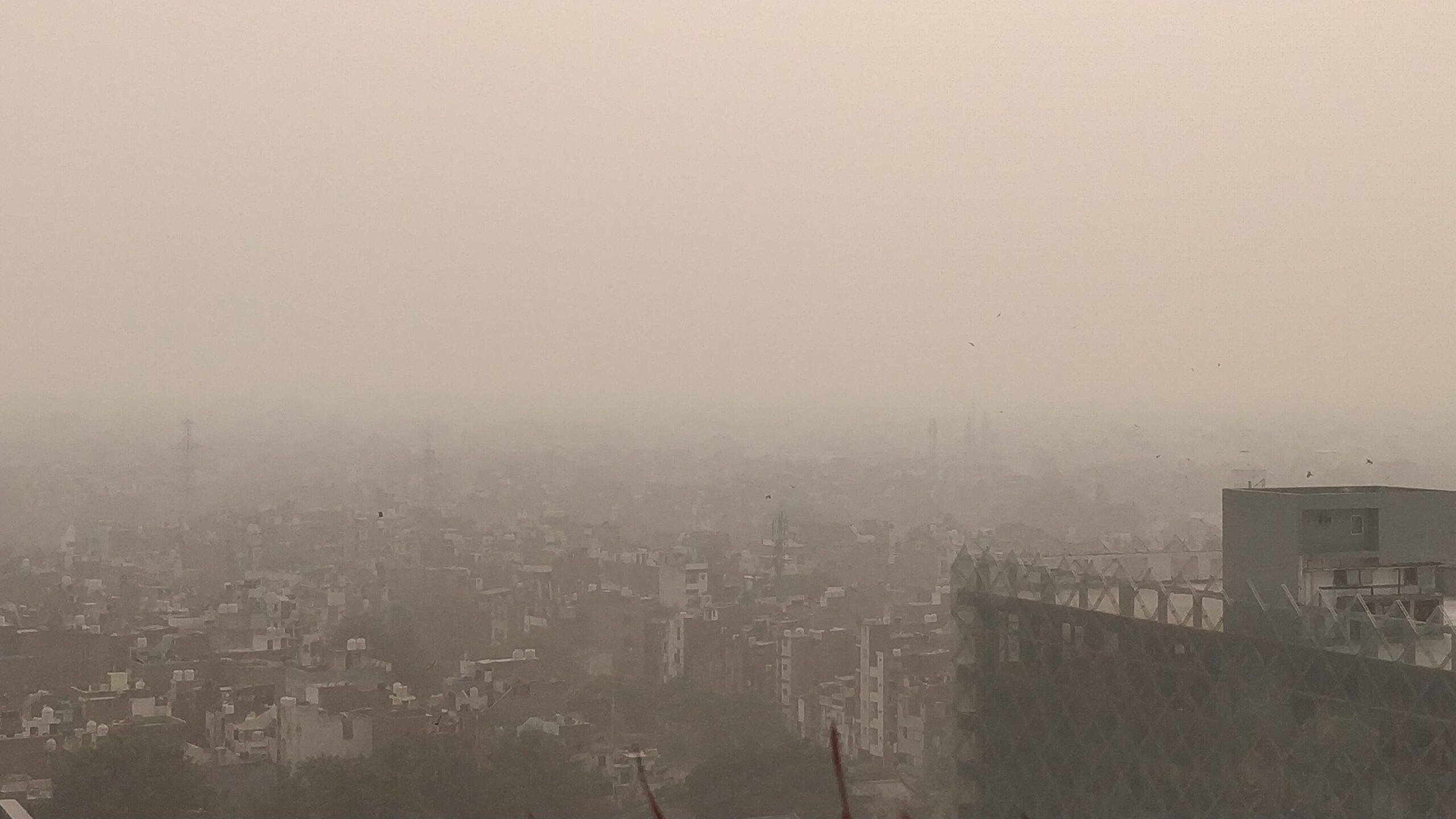 Thick grey smog hanging over rooftops and buildings across Delhi during a winter pollution episode in 2019